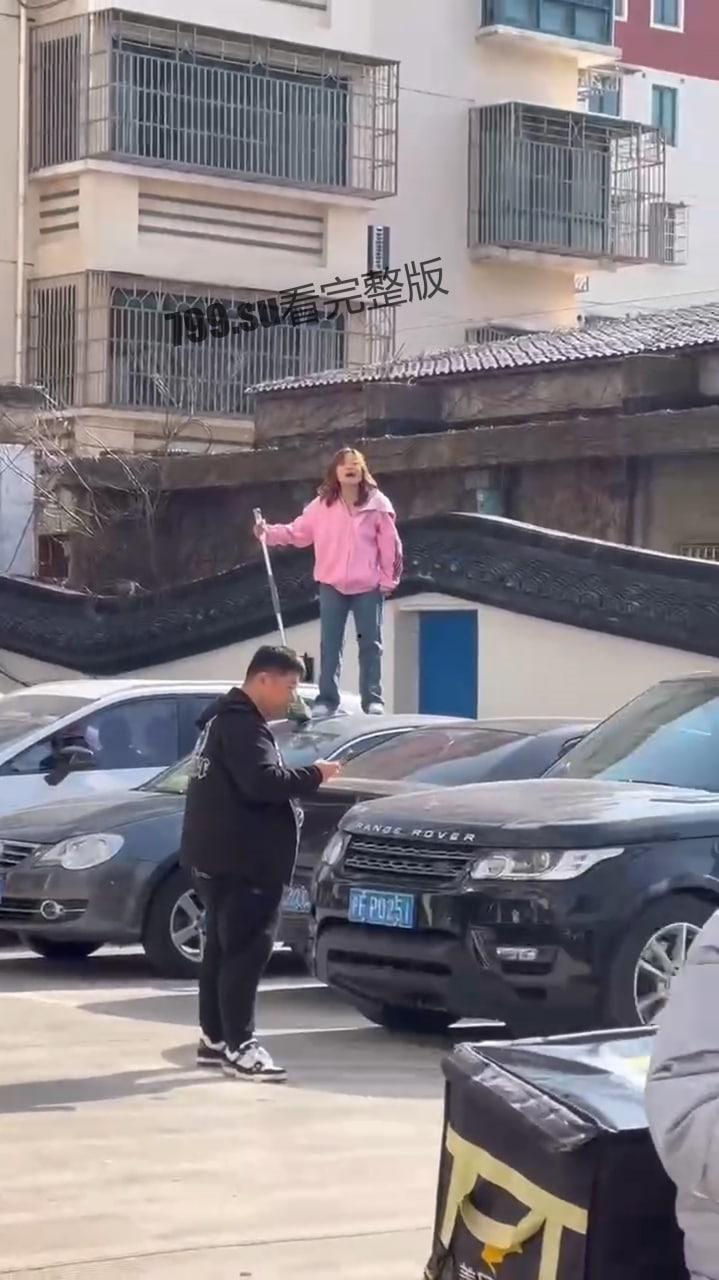 江苏南通 有一女子站在车上 还砸坏车辆 疑似精神有问题  第1张